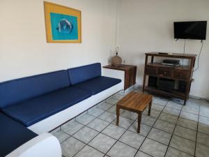 sala de estar con sofá azul y mesa en CASA PLAYITA MELAQUE, en San Patricio Melaque