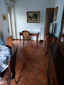 un soggiorno con scrivania, tavolo e sedie di Casa Roncaccia a Grottaferrata