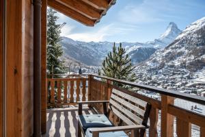 a balcony with a bench and a view of the mountains at Apartment Montana in Zermatt