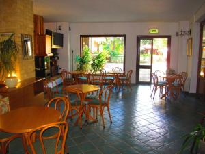 a restaurant with wooden tables and chairs and a kitchen at Hotel Pagnani in Pescasseroli