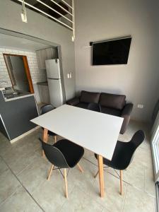uma mesa branca e cadeiras num quarto com um sofá em PEDROSAS Departamentos em Villa Elisa