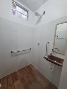 baño con espejo y lavabo en Vila Shangri-la Algodoal- Suítes e Redário en Algodoal