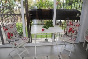 a white table and two chairs in front of a window at N&AA apartman in Belgrade
