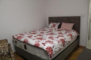 a bed with a red and white comforter on it at N&AA apartman in Belgrade