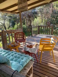 a patio with chairs and a couch on a deck at Mobilhome à la campagne in Porto-Vecchio