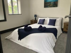 a bedroom with a large white bed with blue pillows at Little Elm - luxury home from home, free parking, 30-40 mins walk from Bath city centre in Bath +6 photos
