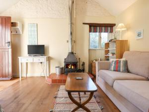 a living room with a couch and a wood stove at The Calf Pen in Colyton