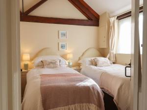 a bedroom with two beds and a window at The Calf Pen in Colyton