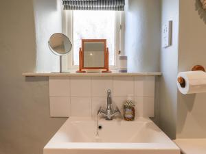 a bathroom sink with a mirror and a window at The Calf Pen in Colyton +24 photos