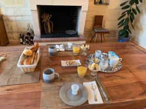 a table with food and drinks and a fireplace at Suite privative Abella - Aile de maison bourgeoise in Ambarès-et-Lagrave