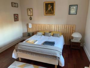 een slaapkamer met een groot bed met een houten hoofdeinde bij Suite privative Abella - Aile de maison bourgeoise in Ambarès-et-Lagrave