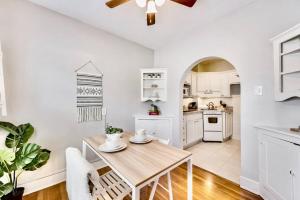 a white kitchen with a wooden table and chairs at Global Cup Natural Sabbatical 1 Bedroom Apartment in Dallas