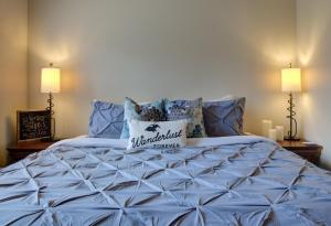 a bedroom with a blue bed with two lamps at Misty Mountain- Premium 2 Bedroom Mountain View in Canmore +19 photos