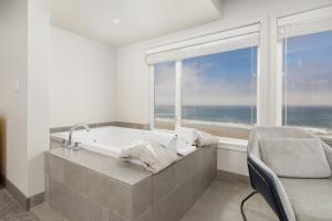 a bath tub in a room with a view of the ocean at Surfland Hotel in Lincoln City