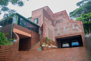 a brick building with a garage with a car in it at Golden Guesthouse Durban in Durban