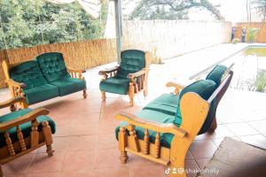 three chairs and a couch on a patio at Golden Guesthouse Durban in Durban