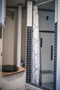 a bathroom with black and white tile on the wall at Log Cabin from 1820s with wood-heated sauna in Hassela