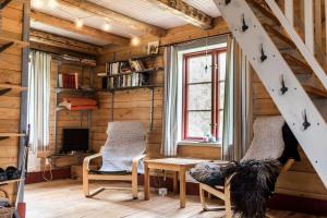 a room with two chairs and a table and a window at Log Cabin from 1820s with wood-heated sauna in Hassela