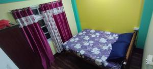 a small bedroom with a bed with purple sheets at Roofscape Homestay in Darjeeling