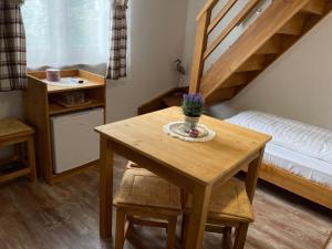 Habitación pequeña con mesa de madera y cama en Székelyudvar Fogadó, en Lukácsháza