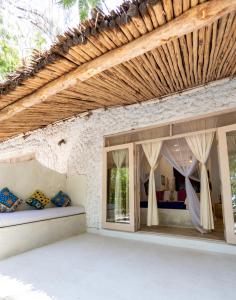 ein Schlafzimmer in einem Haus mit Fenstern und einem Dach in der Unterkunft Sharazad Oasis Retreat in Jambiani