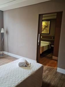 a hotel room with a bed and a mirror at San Juan Royal in Curitiba