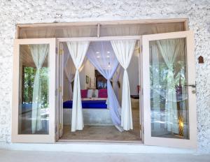 a room with doors open to a bedroom at Sharazad Oasis Retreat in Jambiani