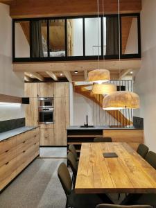 a kitchen with a wooden table and some chairs at Arcs 1950 , CALM Comme A La Montagne in Arc 1950