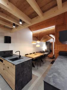 a kitchen with a wooden table and a dining room at Arcs 1950 , CALM Comme A La Montagne in Arc 1950