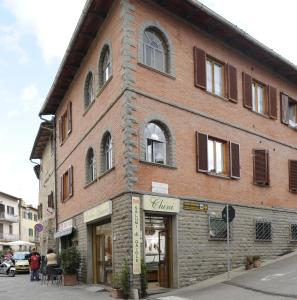 un grande edificio in mattoni all'angolo di una strada di Osteria Carnivora Guest House a Gaiole in Chianti