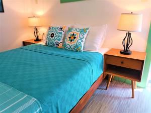 1 dormitorio con 1 cama y mesita de noche con 2 lámparas en Lazy Guesthouse, en Vieques