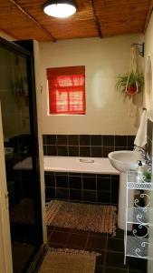 een badkamer met een wastafel en een bad bij Cottage K'Gari in Franschhoek