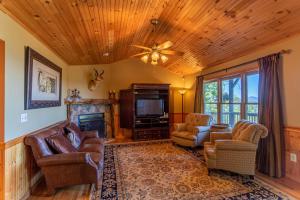 a living room with leather furniture and a tv at Chipmunk View Lodge in Blowing Rock