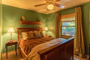 a bedroom with a bed with green walls and a window at Chipmunk View Lodge in Blowing Rock
