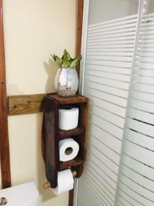 un porte-papier toilette avec un vase au-dessus dans l'établissement Rustic House Punta Rucia, à Punta Rucia