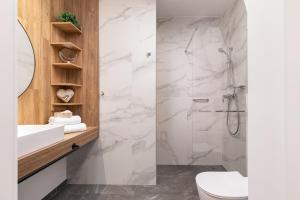 y baño con aseo, lavabo y ducha. en Mielno Jantaris- Apartament B3- przy plaży, en Mielno