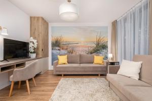 sala de estar con sofá y TV en Mielno Jantaris- Apartament B3- przy plaży, en Mielno