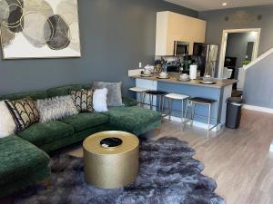 a living room with a green couch and a kitchen at Scott’s Addition in Richmond