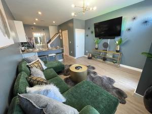a living room with a green couch and a flat screen tv at Scott’s Addition in Richmond