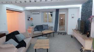ein Wohnzimmer mit einem Sofa und einem TV in der Unterkunft maison en pierre avec balnéo entre Toul et nancy 