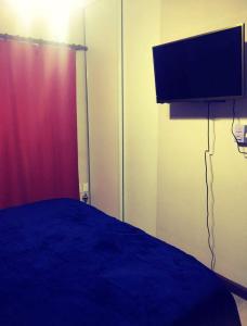 1 dormitorio con 1 cama y TV de pantalla plana en Azucena Apart en Salta