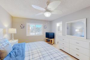 a bedroom with a bed and a ceiling fan at Reef Club 105 in Clearwater Beach