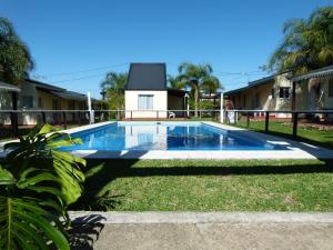 a swimming pool in the yard of a house at Los Palmares Del Urugua-i Bungalows in Colón