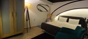 a bedroom with a bed and a blue chair at 10 PERCENT OFF UNTIL 31ST OF OCTOBER - Old Café Spa Apartment in Belgrade