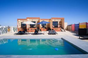 a swimming pool with chairs and umbrellas on a roof at Casas VV in Valle de Guadalupe