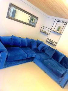 um sofá azul numa sala de estar com dois espelhos em Hunters Hideaway-Hot Tub-Wiltshire-Groups em Warminster