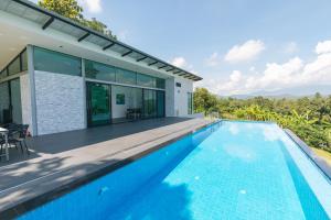 an image of a swimming pool in front of a house at Roxana Resort in Hang Dong
