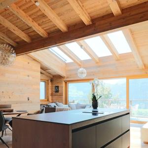 a kitchen and living room with a large window at Kitzbüheler Alpenpenthouse *private Sauna&Whirlpool* by STELLENBERG living in Hollersbach im Pinzgau