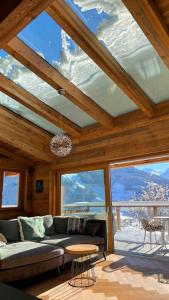 a living room with a couch and a ceiling with windows at Kitzbüheler Alpenpenthouse *private Sauna&Whirlpool* by STELLENBERG living in Hollersbach im Pinzgau