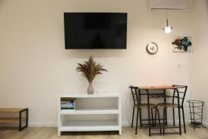 ein Wohnzimmer mit einem Tisch und einem TV an der Wand in der Unterkunft Blloku Studio Apartament in Tirana